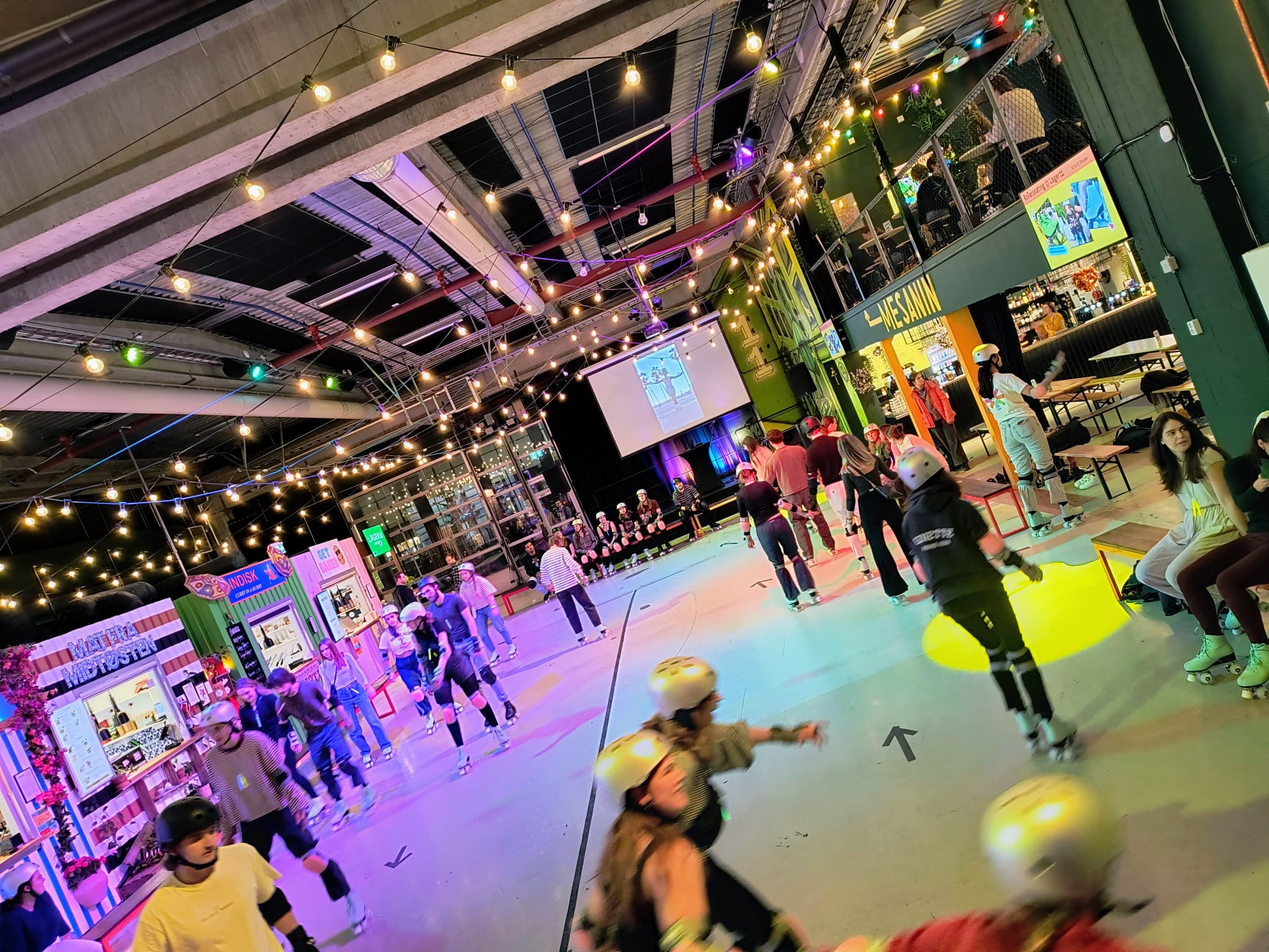 Familier og venner som ruller sammen hos Magic Roller Rink